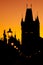 The silhouettes of towers and statues on Charles Bridge in Prague