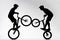 silhouettes of trial bikers performing stunt synchronously