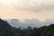 Silhouettes tropical hazy mountains and the green jungle trees in the foreground