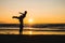 Silhouettes of two dancers doing acrobatics at sunset