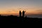 Silhouettes of two fishermen getting ready at sunset to fishing