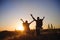 Silhouettes of two hikers with backpacks walking at sunset. Trekking and enjoying the sunset view.