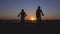 Silhouettes of two members of family - mother and son - riding their mountain bicycles near lake in amazing rays of