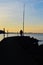 Silhouettes of two men on the pier, at sunset