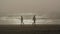 Silhouettes of two persons walking in an opposite directions on a Tillamook beach, Oregon