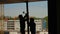 Silhouettes of two workers assemble a metal beam