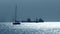 Silhouettes of an unknown sailboats and cargo ships near Gibraltar