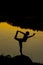 Silhouettes of a woman doing yoga at sunset