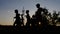 Silhouettes of young boys, jogging on a training against the sunset