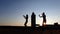 Silhouettes of young girls dancing at sunset on roof
