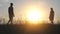 Silhouettes of young parents meeting on the background of the beautiful evening sun and parting right there.