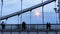 Silhouettes of young people on steel bridge in dusk