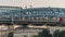 Silhouettes of young people strolling and taking pictures of each other in a precarious situation on the top of the bridge