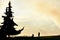 Silhouettes of a young photographer next to another woman sitting admiring the beauty of a large fir tree