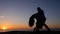 Silhouettes of young spanish couple against sunset sea background. Man and woman dancing latin american sensual dance