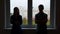 Silhouettes of young spouses against the backdrop of a window in a quarrel.