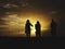 Silhoutte of two women and one man walking during the sunset