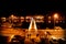 Silhouttes of people on the street crossing the bridge along the port of Zadar at night, Croatia