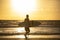 Silhuette of a surfer on a background of beautiful golden sunset