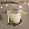 Silicone baby bib light green color on wooden hanger on branch with garland. Square frame, instagram use