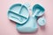 Silicone baby feeding set top view. Toddlers led weaning supplies with suction bowl, divided plate, sippy, bib on color background