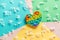 Silicone rainbow antistress toy in the shape of a heart on a cardboard of different colors and fluff. Trendy relaxation tool