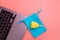 Silicone yellow menstrual cup with blue pouch on notebook. Women\\\'s health and alternative hygiene on a pink background