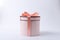 Silk bow and ribbon, pink round gift box on the grey surface.Present box made of pastel colored cardboard