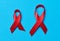 A silk red ribbon in the form of a bow on a blue background, a symbol of the fight against AIDS and a sign of solidarity and