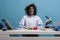 Silly looking crazy chemist with messy hair and dirty face sitting at desk after failed laboratory experiment explosion.