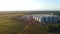 Silo towers for feed storage in the field near the town with sunset light