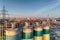 Silos for storage of cement aerial view. Evening shooting, with the setting sun. A large city is visible in the distance