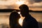 Silouette, loving couple on the lake during sunset. Golden hour
