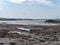 Silt on the exposed seabed at low tide. The shallow sea bay. Seaside landscape