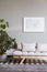 Silver abstract painting on grey wall above scandinavian futon