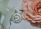 Silver amulet in the form of a clock face on a white background