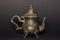 Silver antique kettle on a black background. Chaika made of silver. An antique teapot for tea.