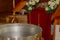 Silver baptismal font with burning candles in a church.