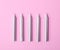 Silver birthday candles on pink background, top