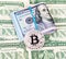 Silver bitcoin of cryptocurrency and folded american dollars