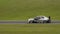 A silver and black Australian Ford Falcon sportscar speeding round corners