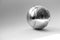 A silver Boule globe lies on a light background