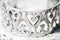 Silver bracelet with hearts ornament closeup. Wedding accessory