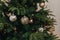 Silver, brown and gold ornaments and balls on the Christmas artificial tree in the house