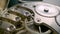 Silver chain and internal working mechanism of an antique pocket watch on a gray background. Clock mechanism macro loop