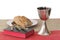 Silver chalice, bible, bread on white background