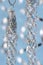 Silver christmas garland hanging on a ribbon on a blue background with bokeh