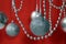 Silver Christmas toys garland beads, balls hang on a red background