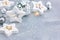 Silver christmas tree balls and garland lights in wooden stars on grey festive background