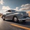 a silver classic car drives down a desert road under a blue sky